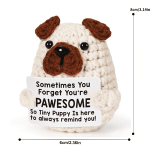 A cute handmade crochet puppy with floppy ears, round black eyes, and a textured body, posed sitting up.