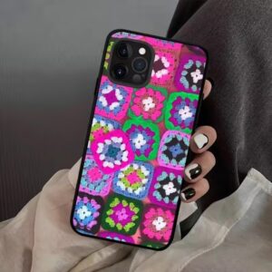 A vibrant handmade granny square crochet iPhone case featuring multi-colored geometric squares and textured stitching.