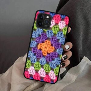 A vibrant granny square crochet iPhone case with multicolored yarn and a classic textured stitch pattern.