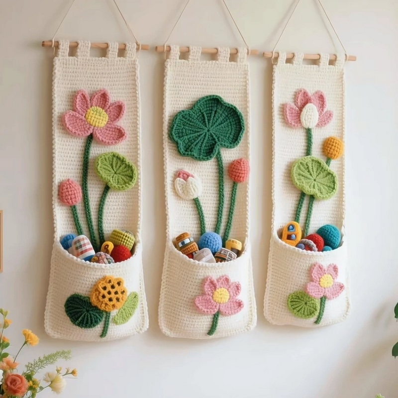 Lotus crochet wall organizer with colorful pockets and tassel trim hanging on a white wall.